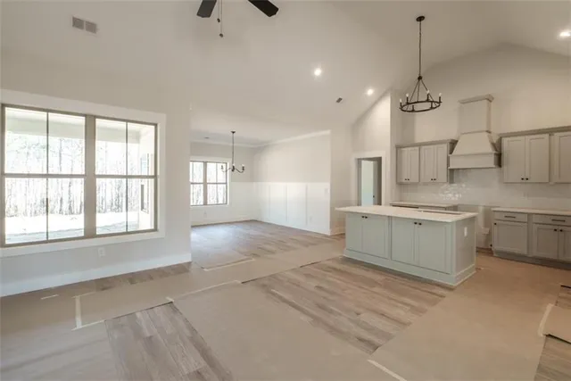a large white kitchen with cabinets a sink a window and a fireplace