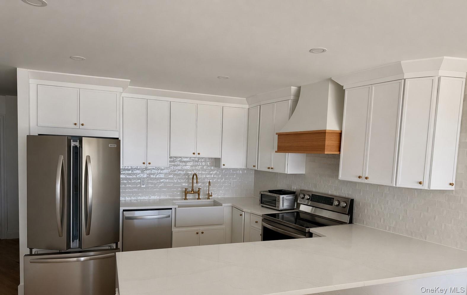 585 Dune Road, Unit B1012 Westhampton, NY 11978 - Photo 3 of 11 a kitchen with stainless steel appliances a refrigerator sink and cabinets