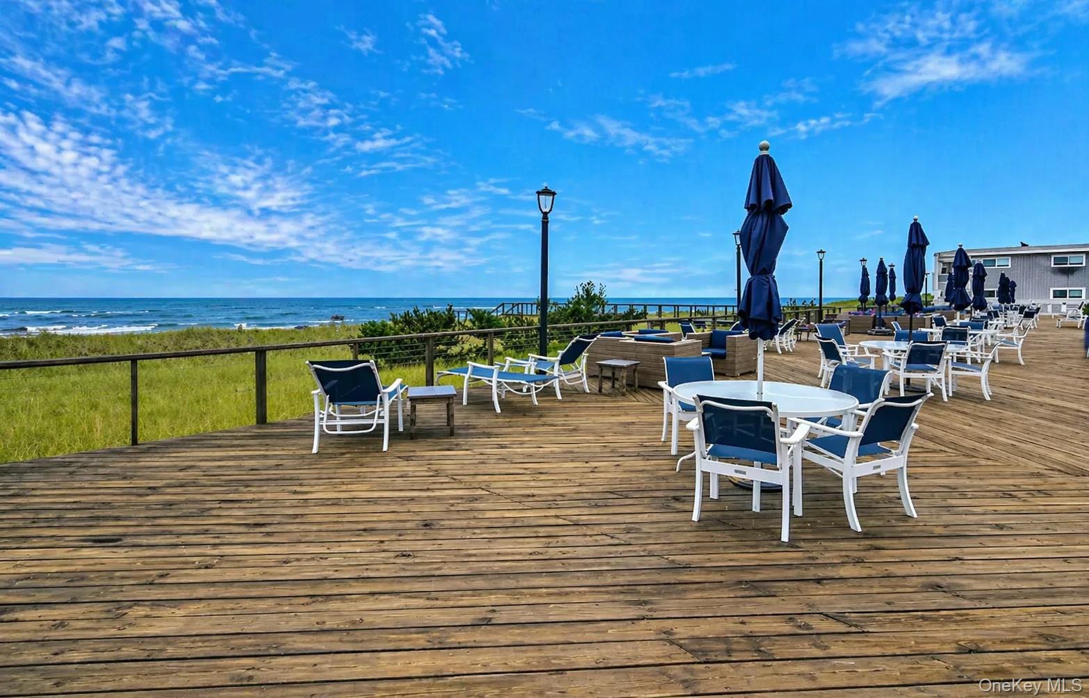 585 Dune Road, Unit B1012 Westhampton, NY 11978 - Photo 10 of 11 a roof deck with table and chairs