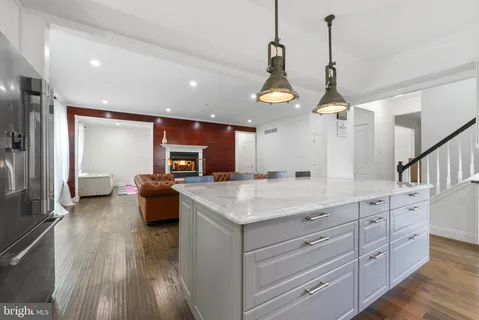a large kitchen with stainless steel appliances granite countertop a stove and a wooden floors