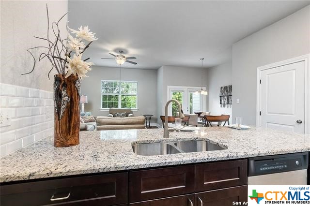 a kitchen with granite countertop a sink a counter top space and windows