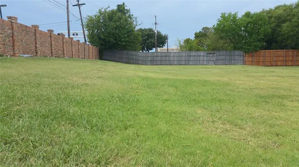 a view of a backyard with wooden fence