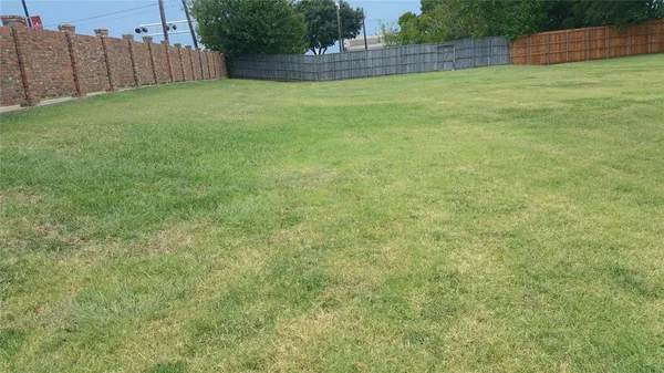 a view of a backyard with wooden fence