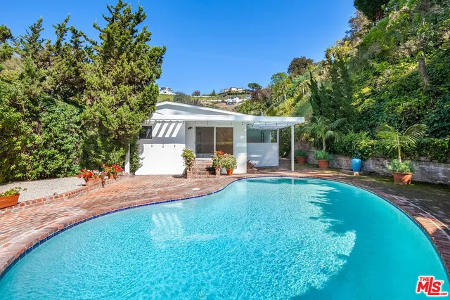 a view of a house with swimming pool and sitting area