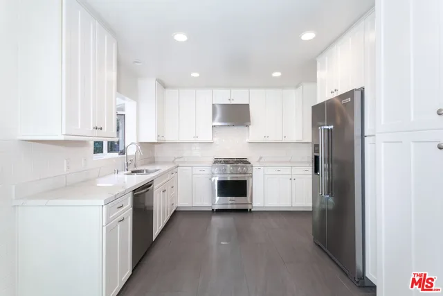 a kitchen with white cabinets and white appliances