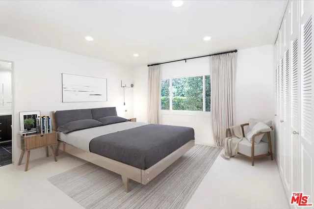 a living room with a bed furniture and a large window