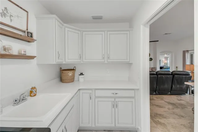 a spacious bedroom with a bed a dresser and wooden floor
