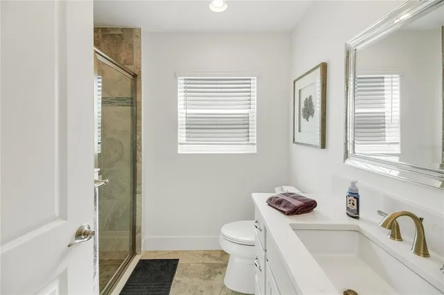 a bathroom with a granite countertop sink toilet and shower
