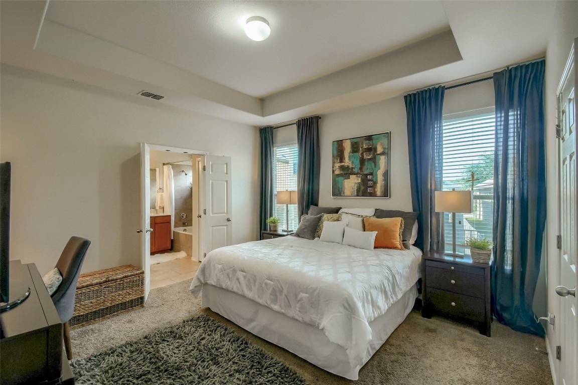 a bedroom with a large bed and a chandelier