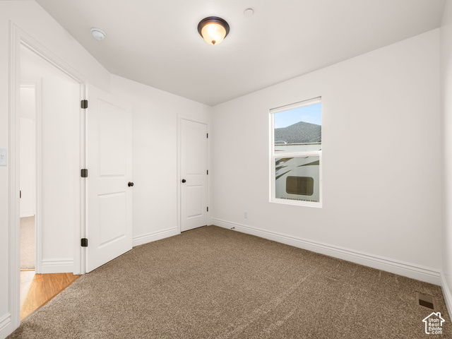 1288 North Horizon View Loop Elk Ridge, UT 84651 - Photo 16 of 38 Carpet flooring, white walls, two solid panel doors with black hardware, flush mount light fixture, and a window with mountain scenery