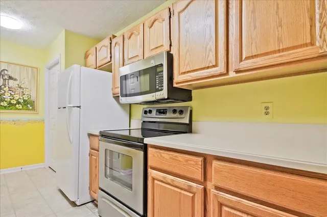 a kitchen with stainless steel appliances granite countertop a refrigerator and a stove