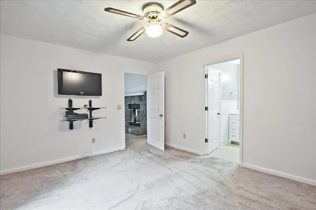 an empty room with a window and a fan