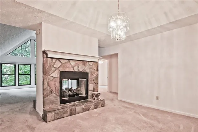 an empty room with fireplace and windows