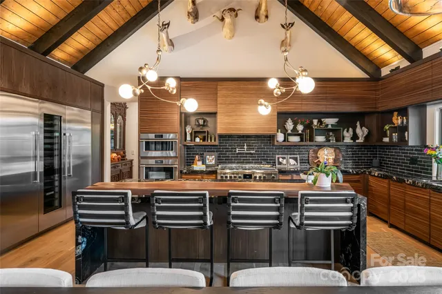 a kitchen with stainless steel appliances granite countertop a stove and a large window