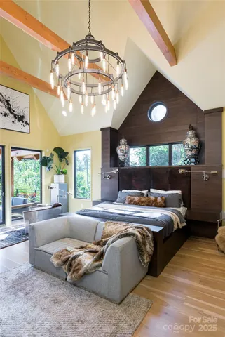 a bed room with a bed mirror and a chandelier