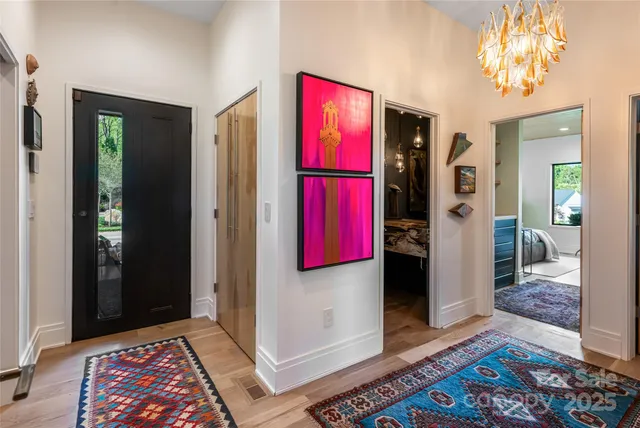 a bedroom with a bed painting on wall and a large window
