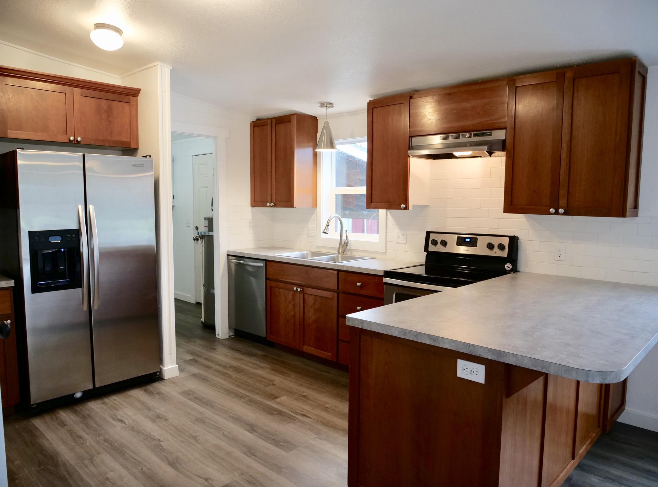 5300 Brickyard Road Tillamook, OR 97141 - Photo 2 of 14 a kitchen with stainless steel appliances kitchen island granite countertop a refrigerator a sink and a stove