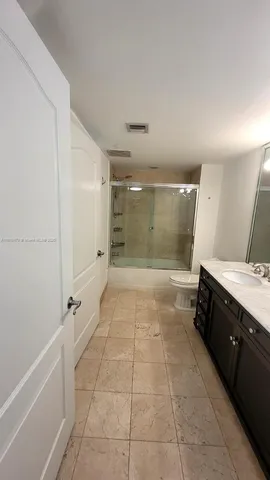 a bathroom with a glass door shower a sink and a mirror