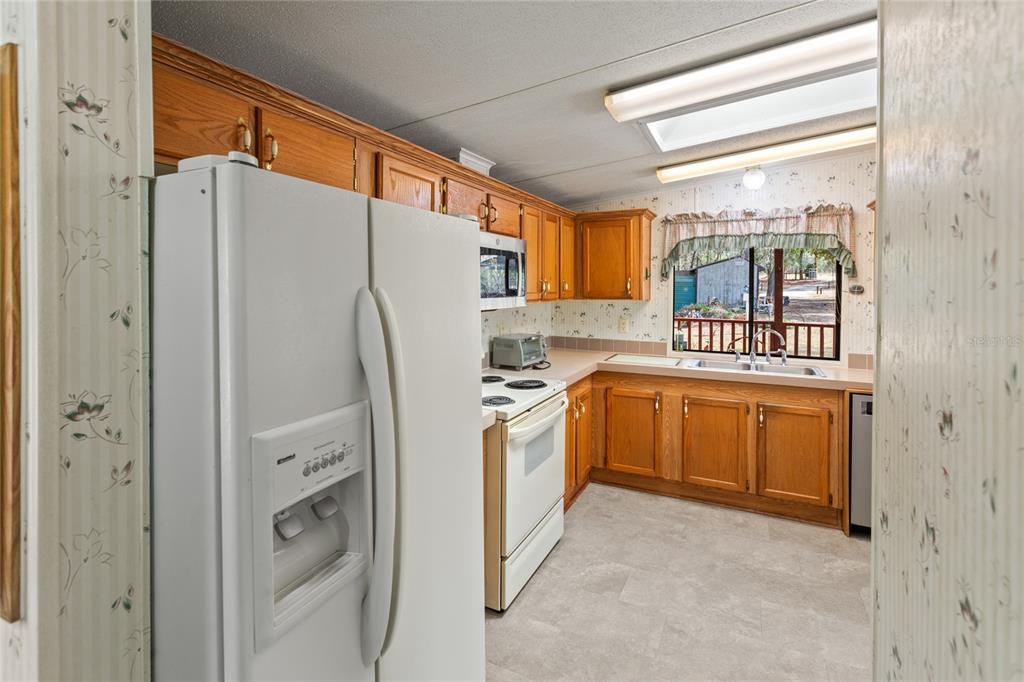 110 Hill Top Loop Hawthorne, FL 32640 - Photo 18 of 52 a kitchen with stainless steel appliances a refrigerator a stove a sink and dishwasher with white cabinets