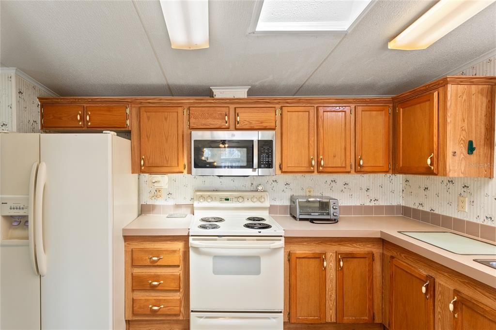 110 Hill Top Loop Hawthorne, FL 32640 - Photo 20 of 52 a kitchen with stainless steel appliances a refrigerator sink and cabinets