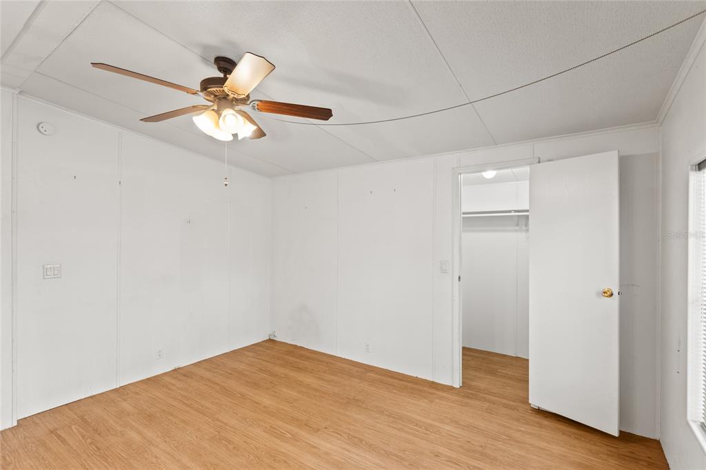 110 Hill Top Loop Hawthorne, FL 32640 - Photo 30 of 52 an empty room with wooden floor fan and windows