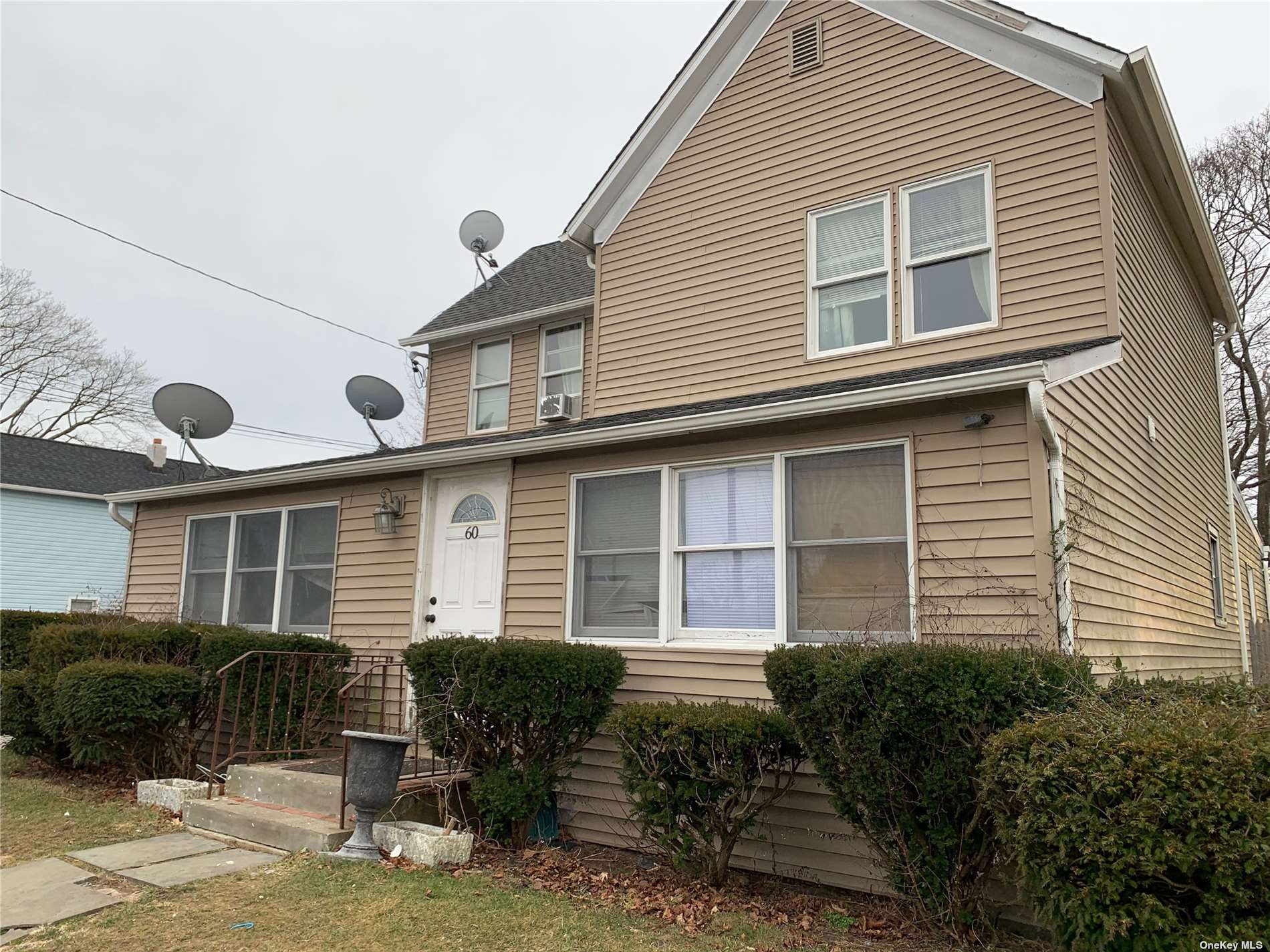 a front view of a house with garden and plants