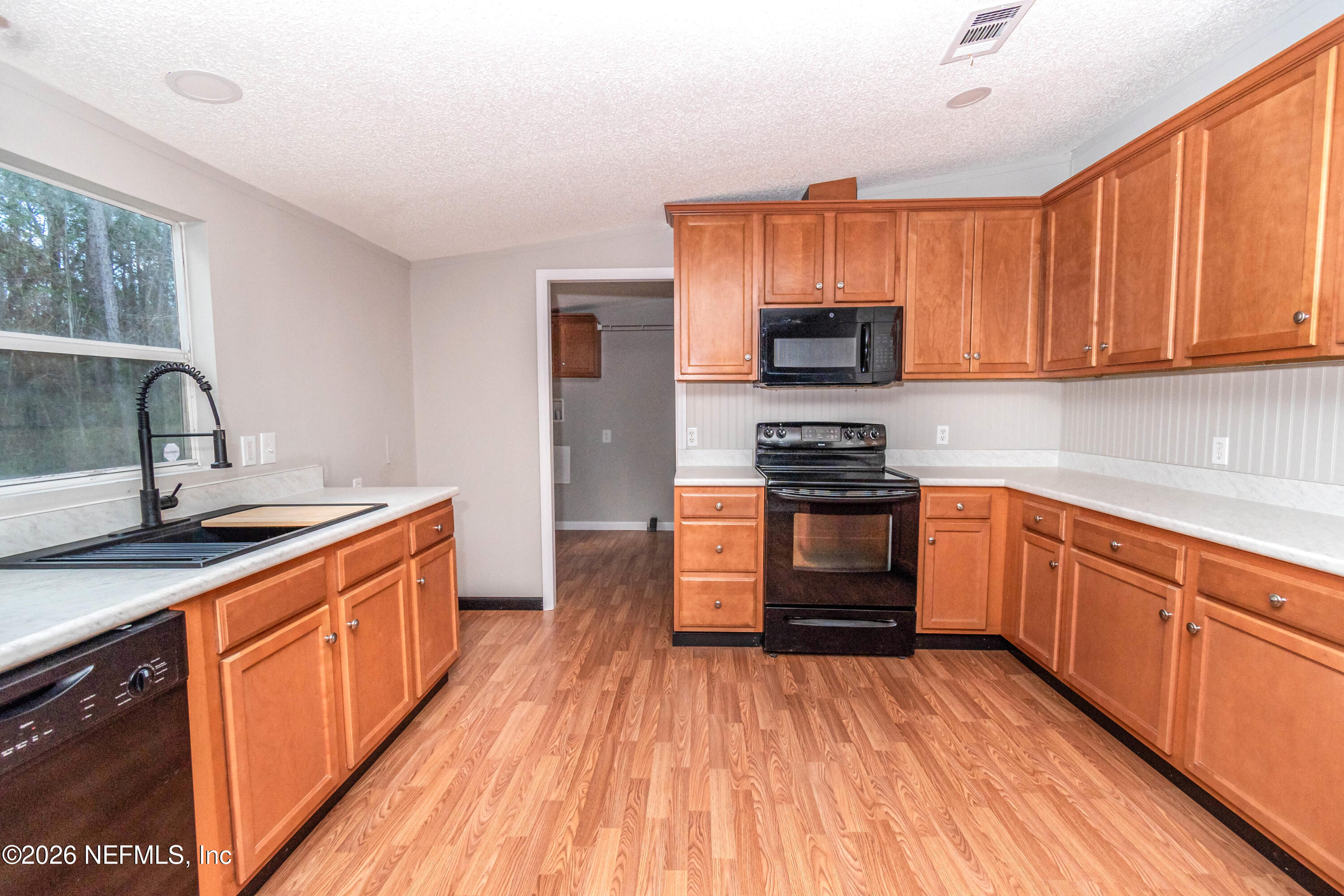 11017 County Road 229 Sanderson, FL 32087 - Photo 6 of 33 a kitchen with granite countertop a stove top oven a sink dishwasher and a refrigerator with wooden cabinets