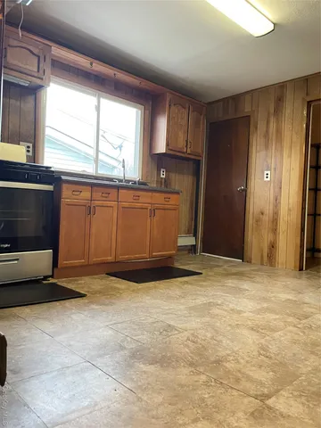 a view of an empty room with a fireplace and a window