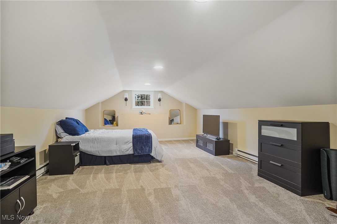 33825 Cannon Road Solon, OH 44139 - Photo 28 of 44 Master Bedroom featuring light colored carpet, vaulted ceiling, a baseboard heating unit, baseboards, and a baseboard radiator