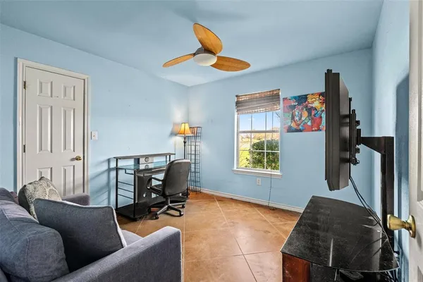 a living room with furniture a ceiling fan and a window