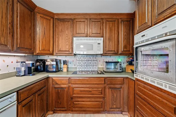 a kitchen with stainless steel appliances granite countertop a sink a stove a refrigerator cabinets and living room view