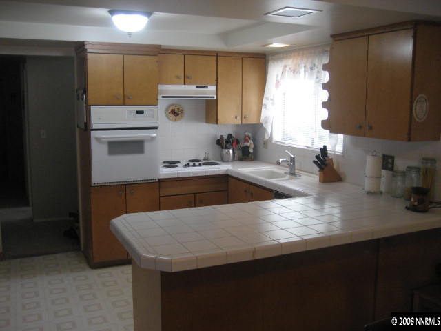 1975 Carlin Street Reno, NV 89503 - Photo 2 of 9 a kitchen with kitchen island a sink dishwasher a refrigerator and a stove with wooden floor