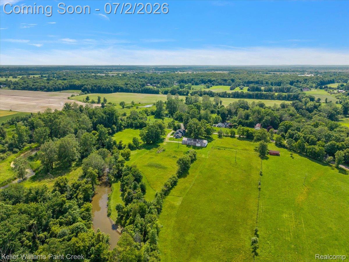 54230 Card Road Macomb, MI 48042 - Photo 25 of 73 Expansive land parcel featuring open fields, wooded areas, and a meandering creek