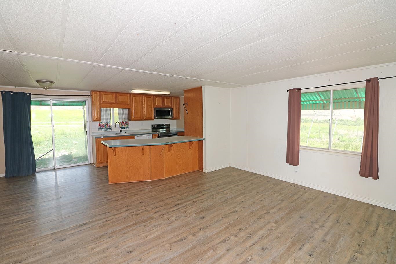 412 35 Road Palisade, CO 81526 - Photo 14 of 39 a large kitchen with stainless steel appliances granite countertop a stove a sink dishwasher a refrigerator and a large window with wooden floor
