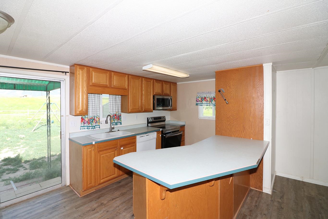 412 35 Road Palisade, CO 81526 - Photo 18 of 39 a kitchen with stainless steel appliances a stove a refrigerator a sink and a dining table with wooden floor