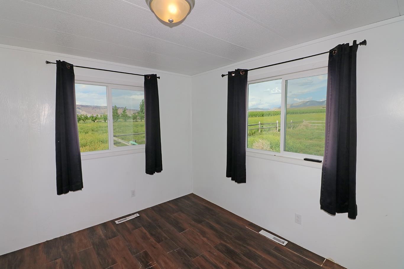 412 35 Road Palisade, CO 81526 - Photo 21 of 39 a view of an empty room with wooden floor and a window