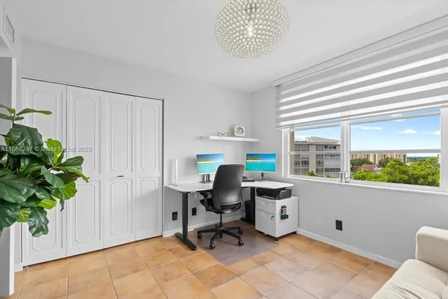 a view of a workspace with furniture and a window