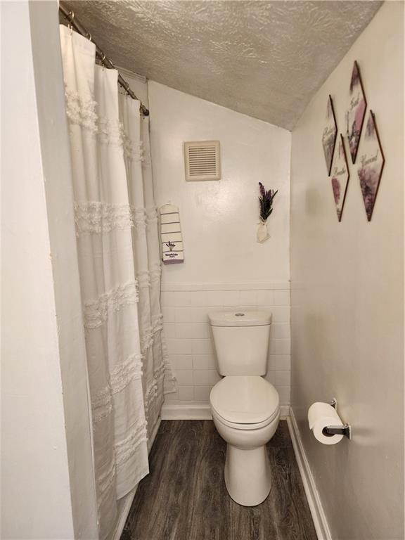 200 Cave Spring Street Southwest Rome, GA 30161 - Photo 10 of 16 a white toilet sitting next to a shower curtain