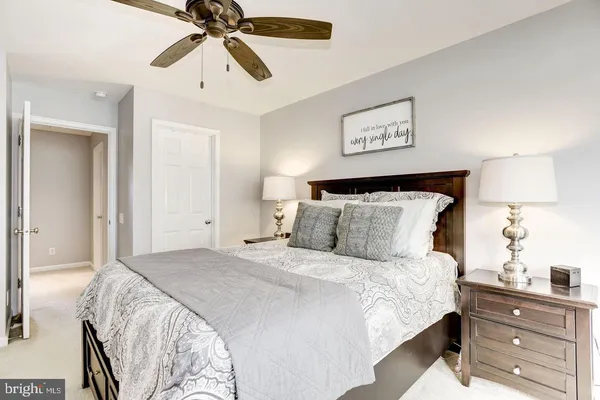 a bedroom with a bed and a lamp on the dresser