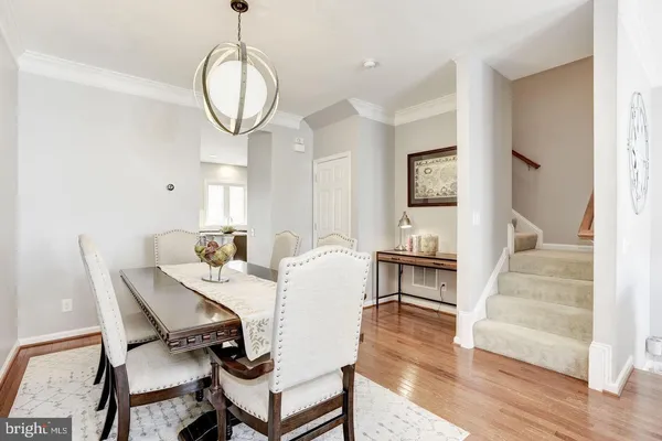 a dining room with wooden floor a glass table and chairs