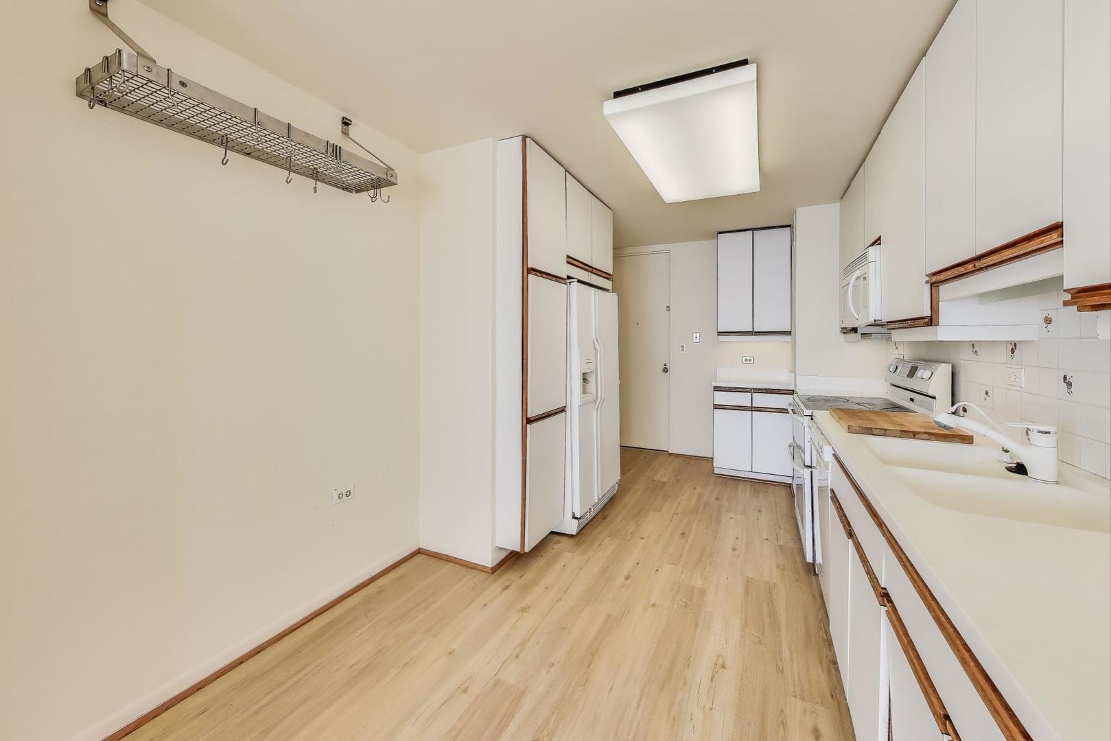 1630 Sheridan Road, Unit 2J Wilmette, IL 60091 - Photo 13 of 50 a view of a kitchen with white cabinets and wooden floor