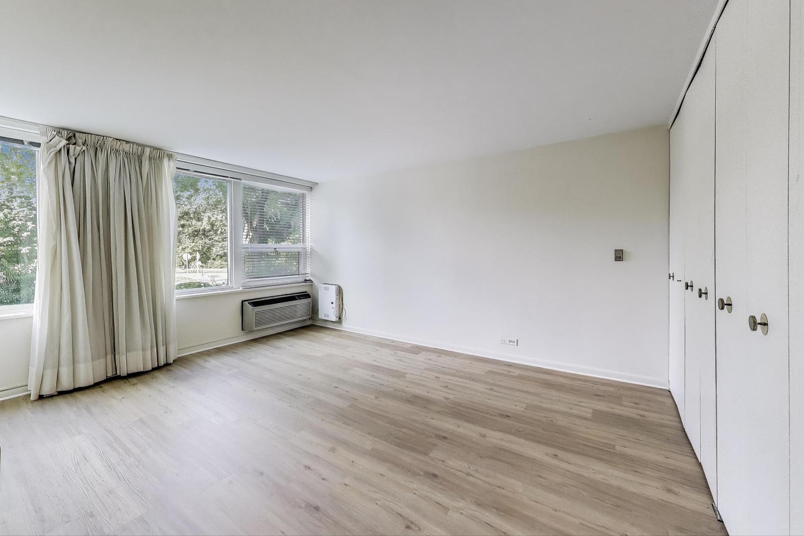 1630 Sheridan Road, Unit 2J Wilmette, IL 60091 - Photo 21 of 50 a view of an empty room with a window and wooden floor
