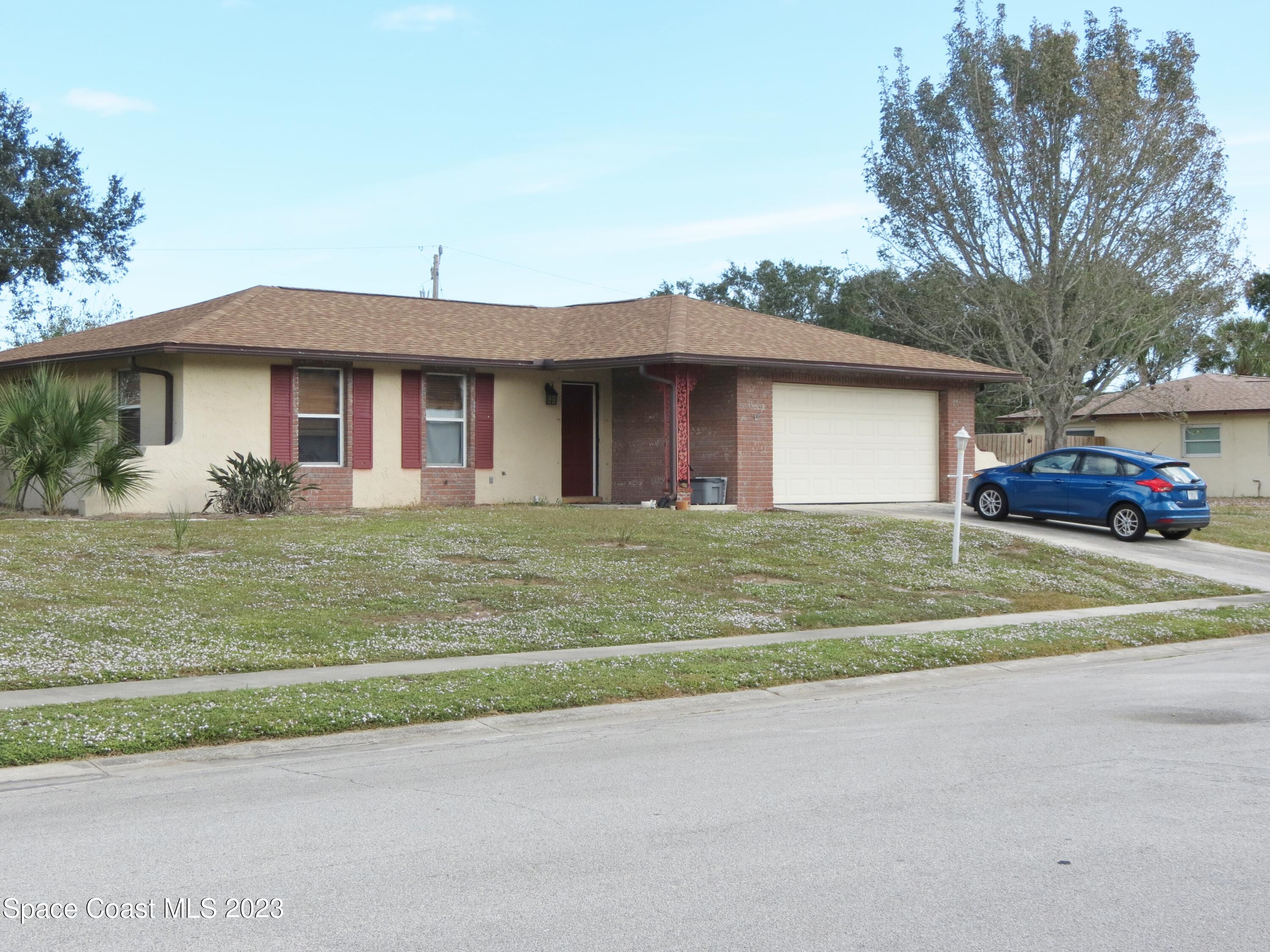 308 Arcadia Avenue Melbourne, FL 32901 - Photo 1 of 4 a front view of a house with a garden and trees