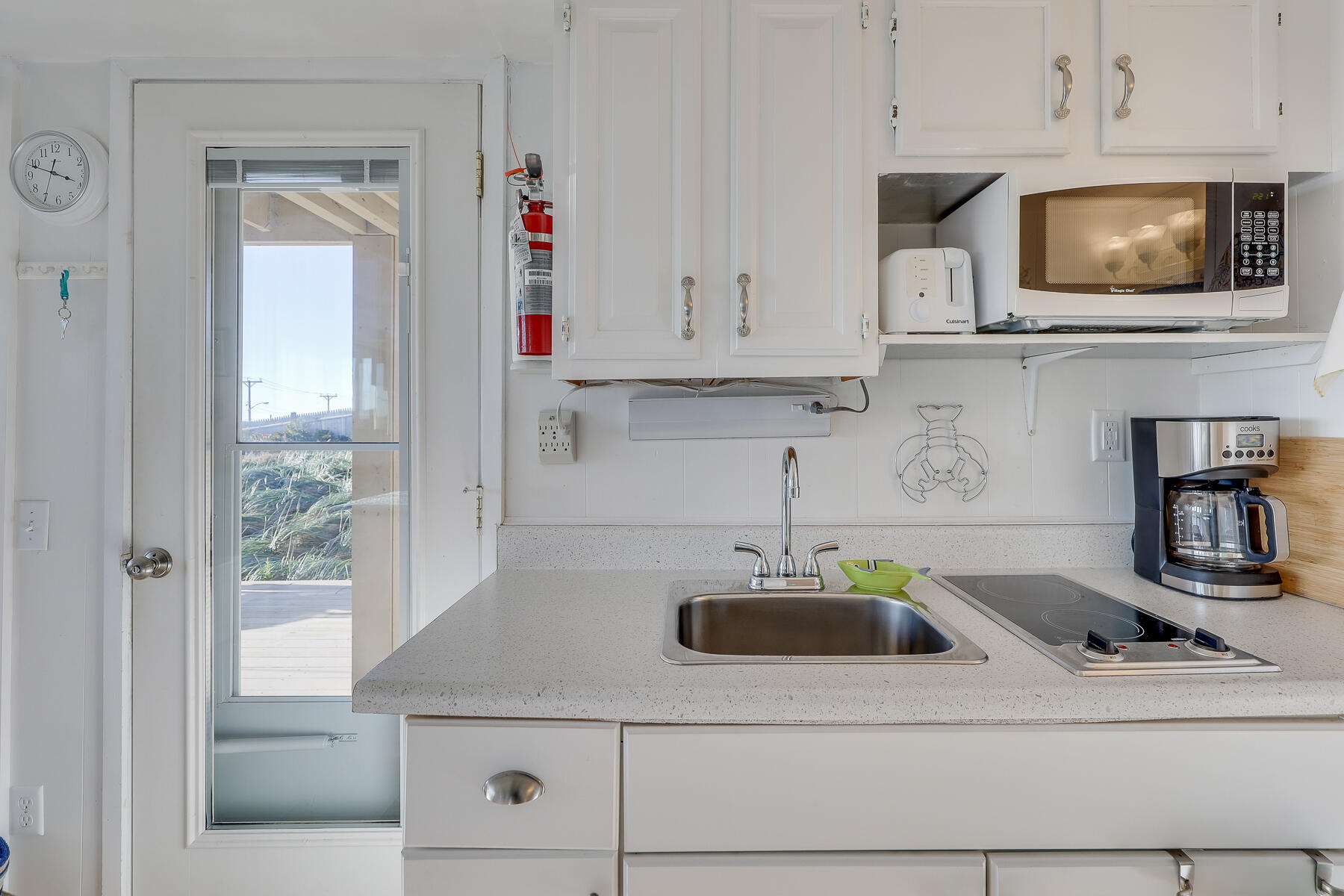 169 Shore Road, Unit 14 Truro, MA 02666 - Photo 12 of 40 a kitchen with stainless steel appliances granite countertop a sink and a white cabinets
