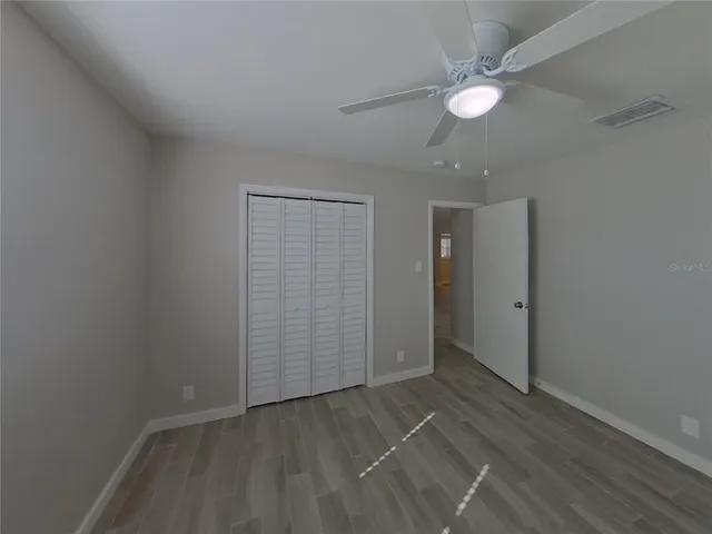 an empty room with closet and fan