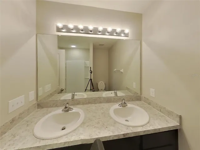 a bathroom with double sink and a mirror