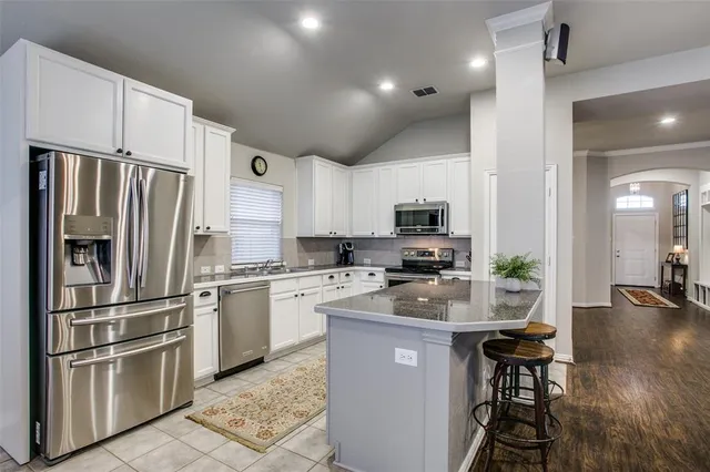 a kitchen with center island table and chairs