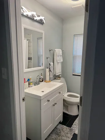 a bathroom with a toilet sink and mirror