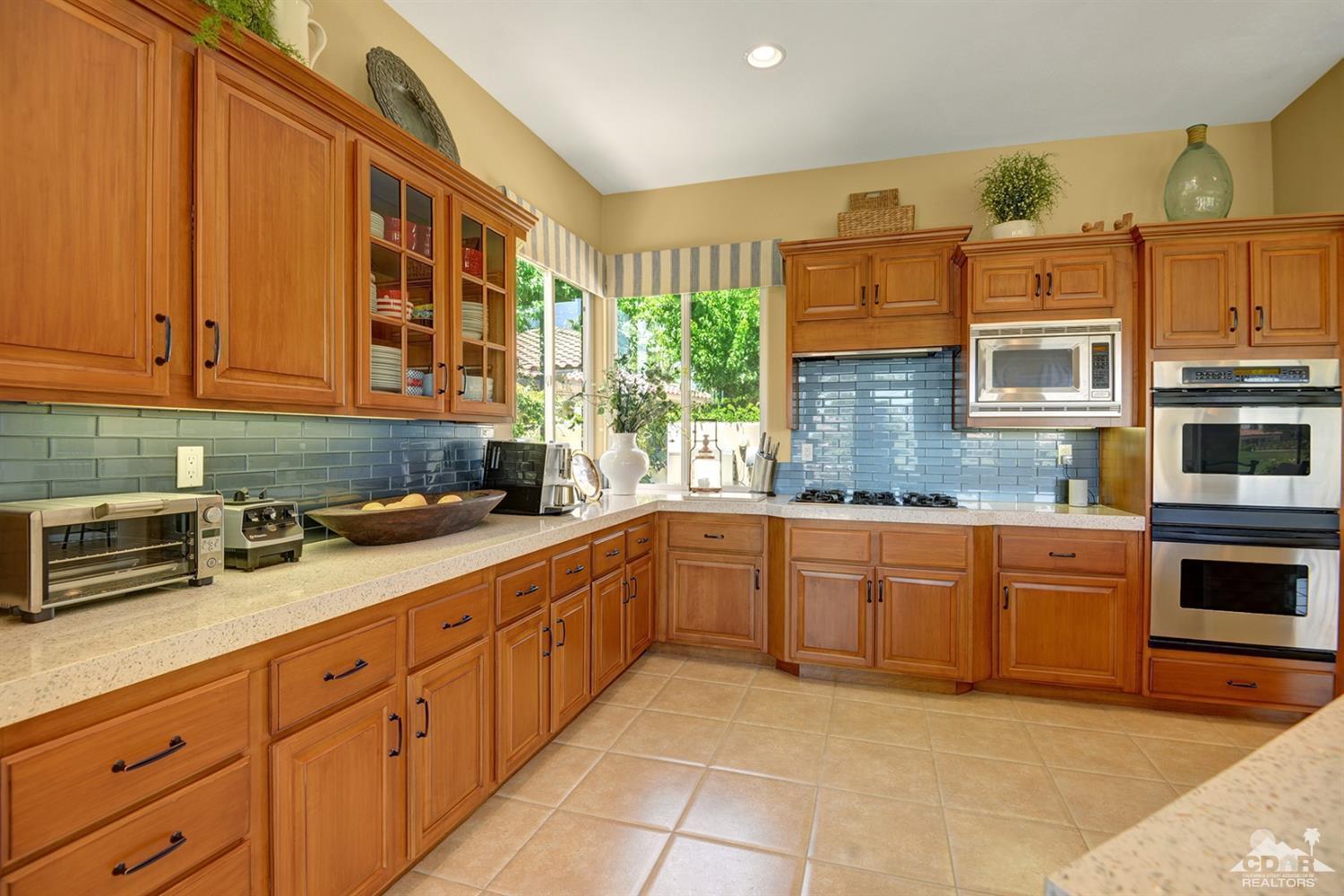 79675 Cetrino La Quinta, CA 92253 - Photo 19 of 34 a kitchen with stainless steel appliances granite countertop a stove sink and cabinets