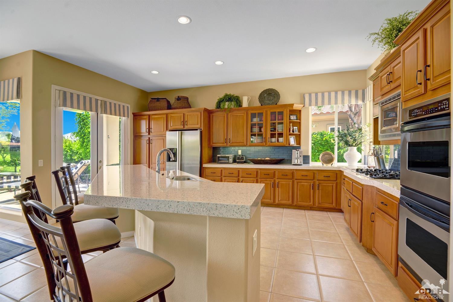 79675 Cetrino La Quinta, CA 92253 - Photo 20 of 34 a kitchen with stainless steel appliances kitchen island granite countertop a table and chairs
